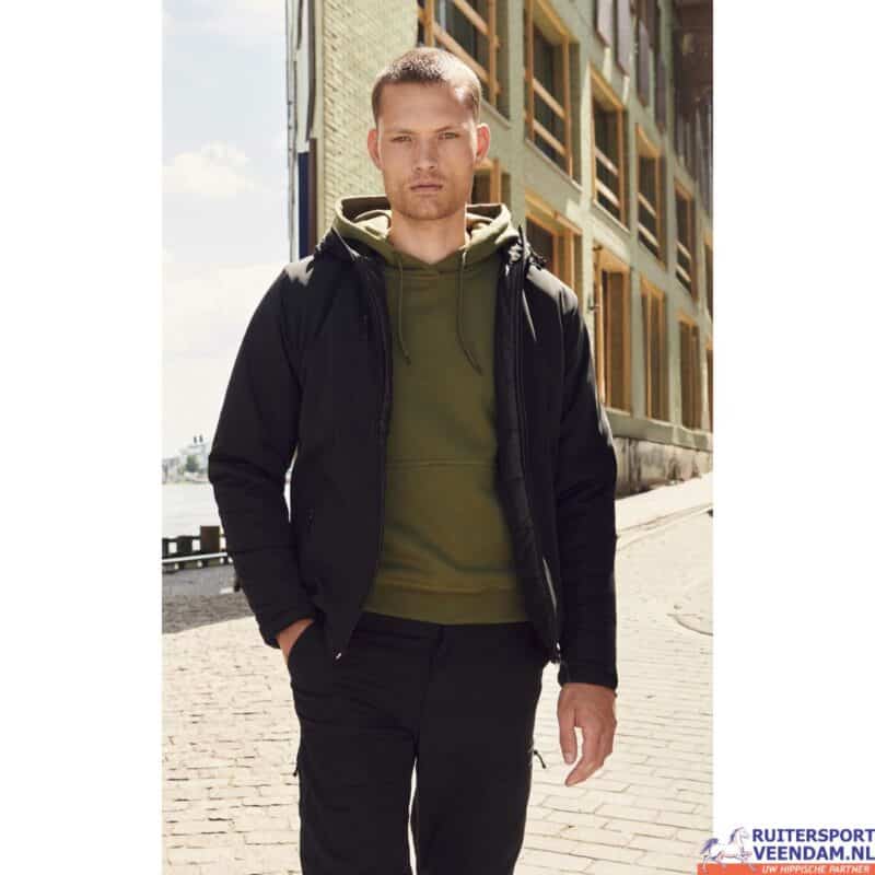 Man draagt een padded softshell hoodie in een stedelijke omgeving.